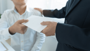 a person handing a piece of paper to another person