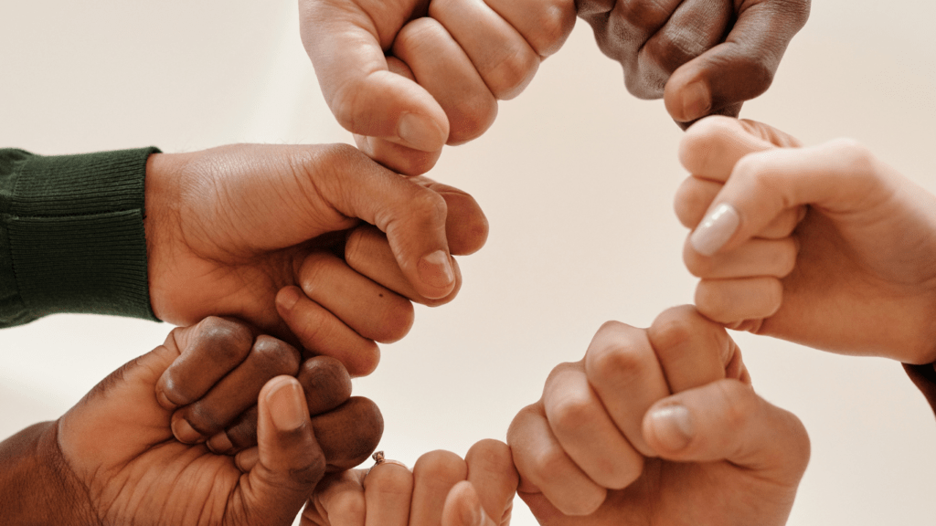 a group of people holding their hands together in a circle