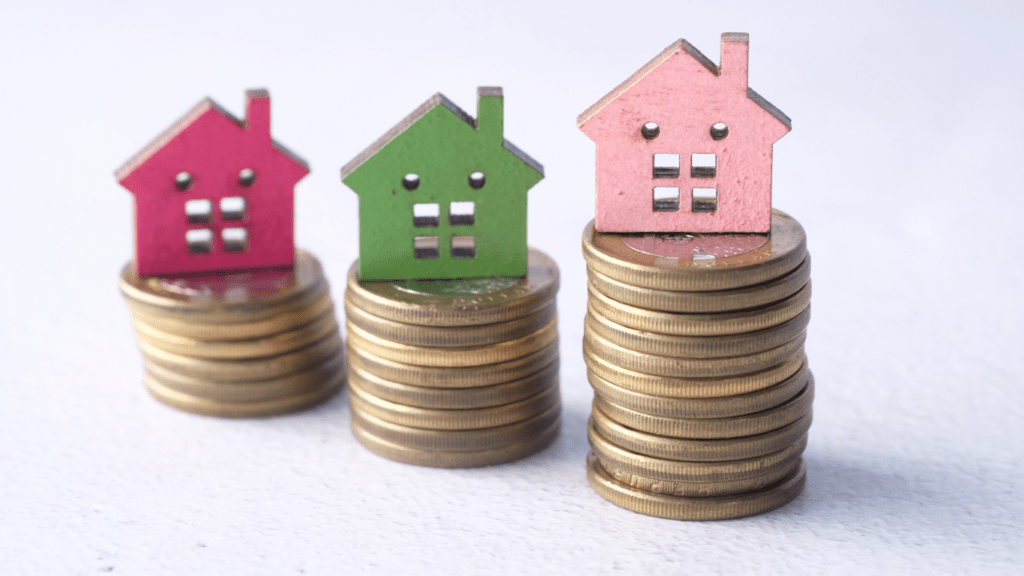 a stack of coins with miniature houses sitting on top of them