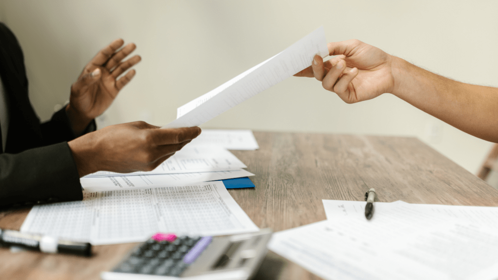 a person handing a piece of paper to another person