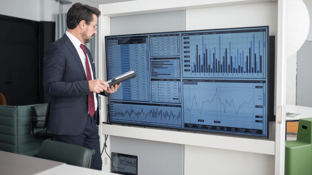 a person in a suit holding a tablet computer and looking at the stock market