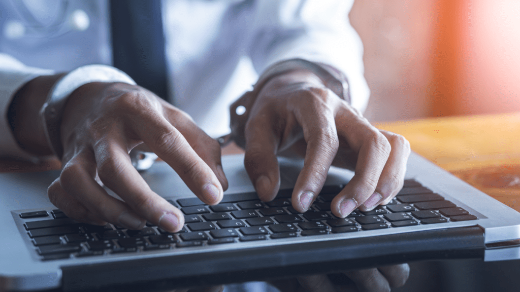 a person in handcuffs holding a laptop computer