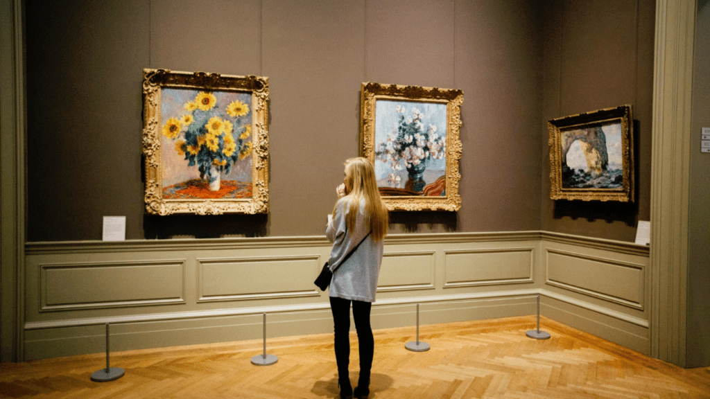 a person looking at paintings in an art museum