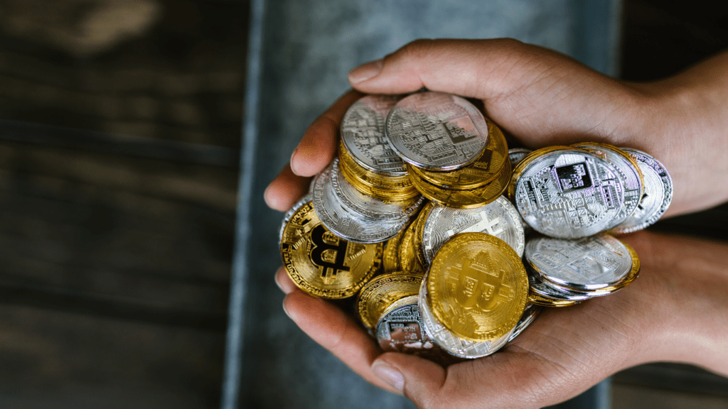 a pile of silver and gold coins on a wooden table